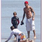 A shirtless David Beckham takes pictures of his sons Brooklyn, Romeo, and Cruz as they try skimboarding on the beach in Malibu A shirtless David Beckham takes pictures of his sons Brooklyn, Romeo, and Cruz as they try skimboarding on the beach in Malibu