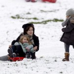 Tim Burton and Helena Bonham Carter take advantage of the snowfall in London by sledding with their kids on Primrose Hill.