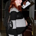 Alyson Hannigan shows off a huge baby bump as she arrives at JFK Airport in New York with husband Alexis Denisof and daughter Satyana.