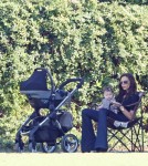 Victoria Beckham keeps baby Harper in the shade while they watch the boys playing soccer .