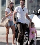 Supermodel Alessandra Ambrosio puts on a furry leopard hat as she walks with her husband Jamie Mazur and daughter Anja Louise
