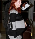 Alyson Hannigan shows off a huge baby bump as she arrives at JFK Airport in New York with husband Alexis Denisof and daughter Satyana.
